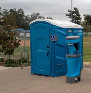 portable toilet and hand washing station near a field